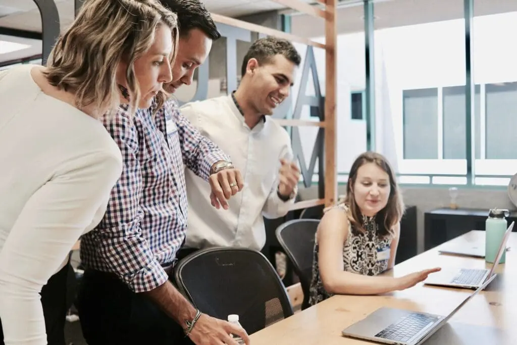 people in the office looking at a laptop