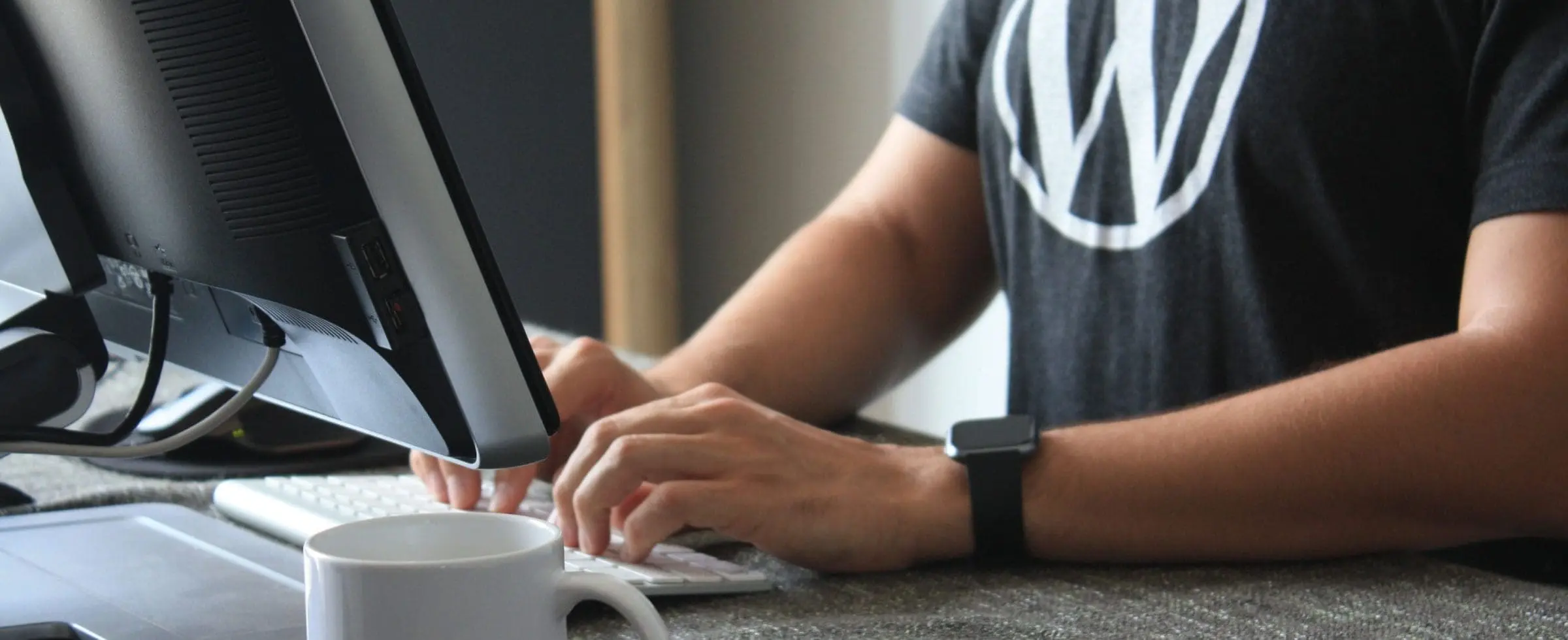a man typing in front of desktop