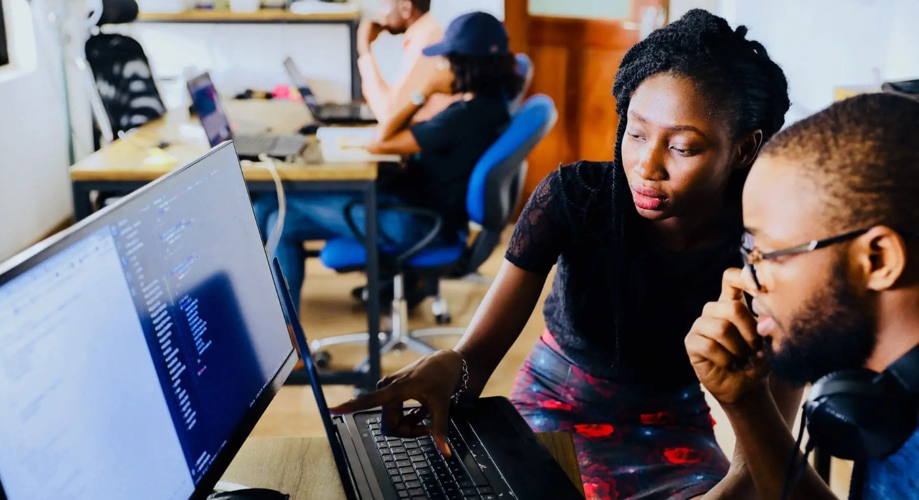 a man and woman working while sitting beside each other