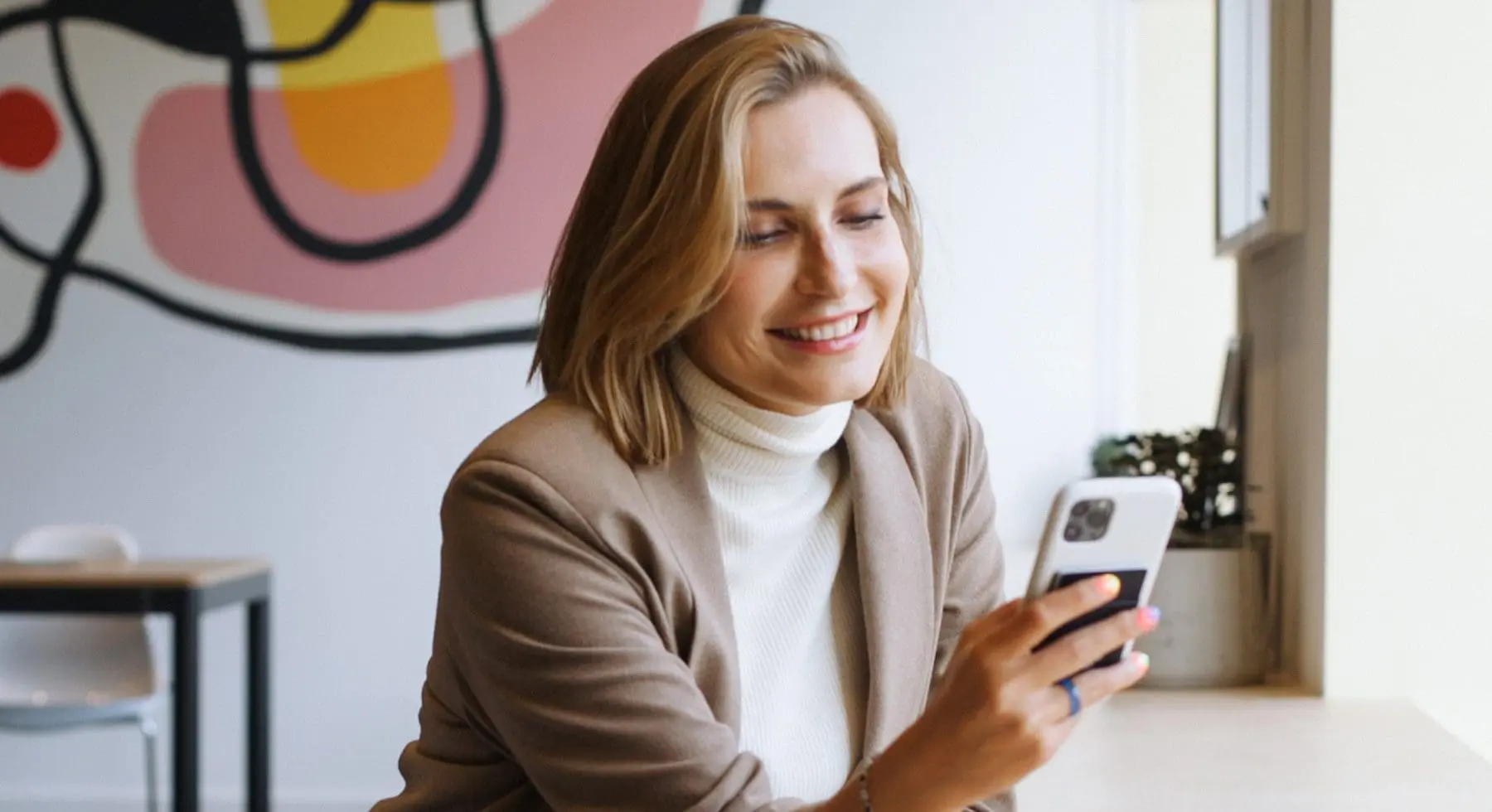a woman looking at her phone smiling