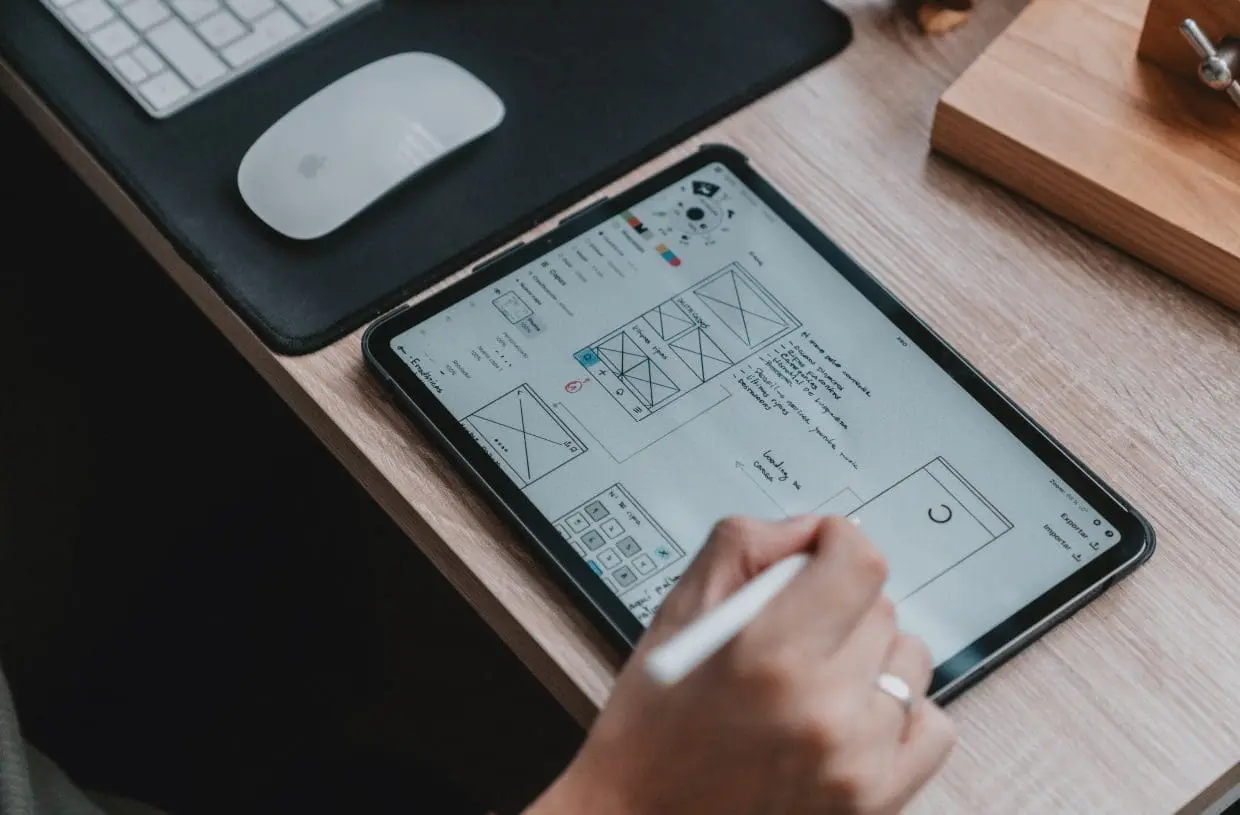 person creating website wireframe on tablet