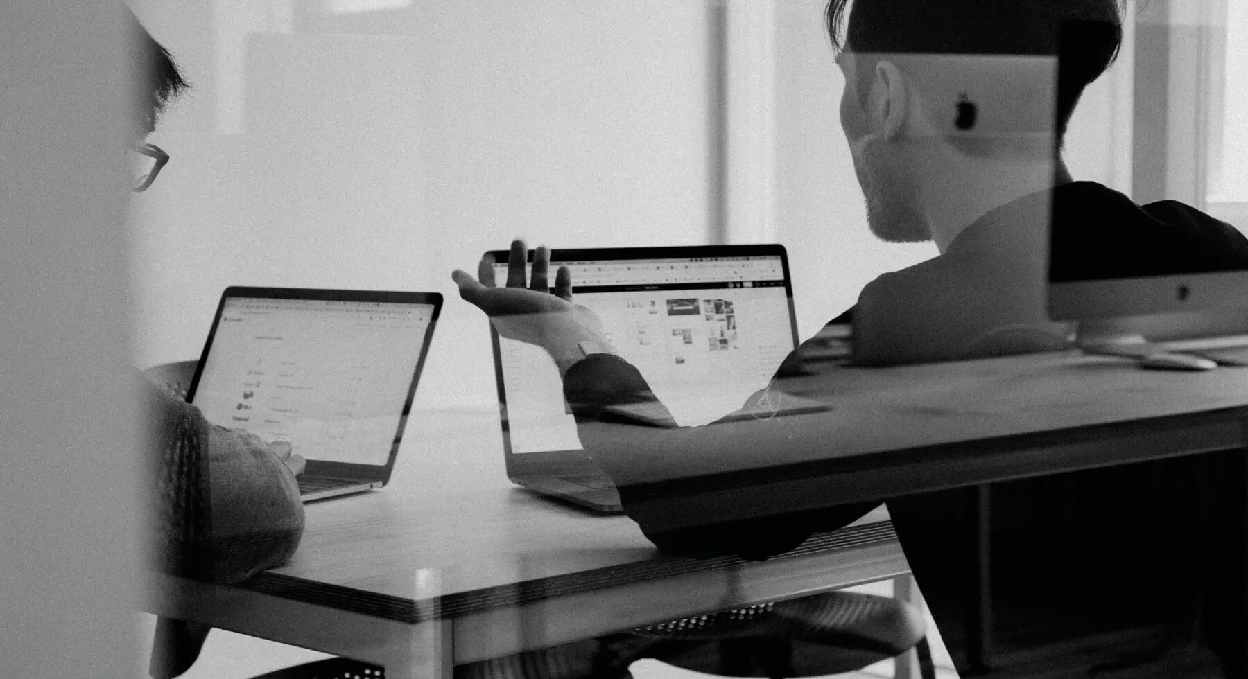 2 man talking with laptops