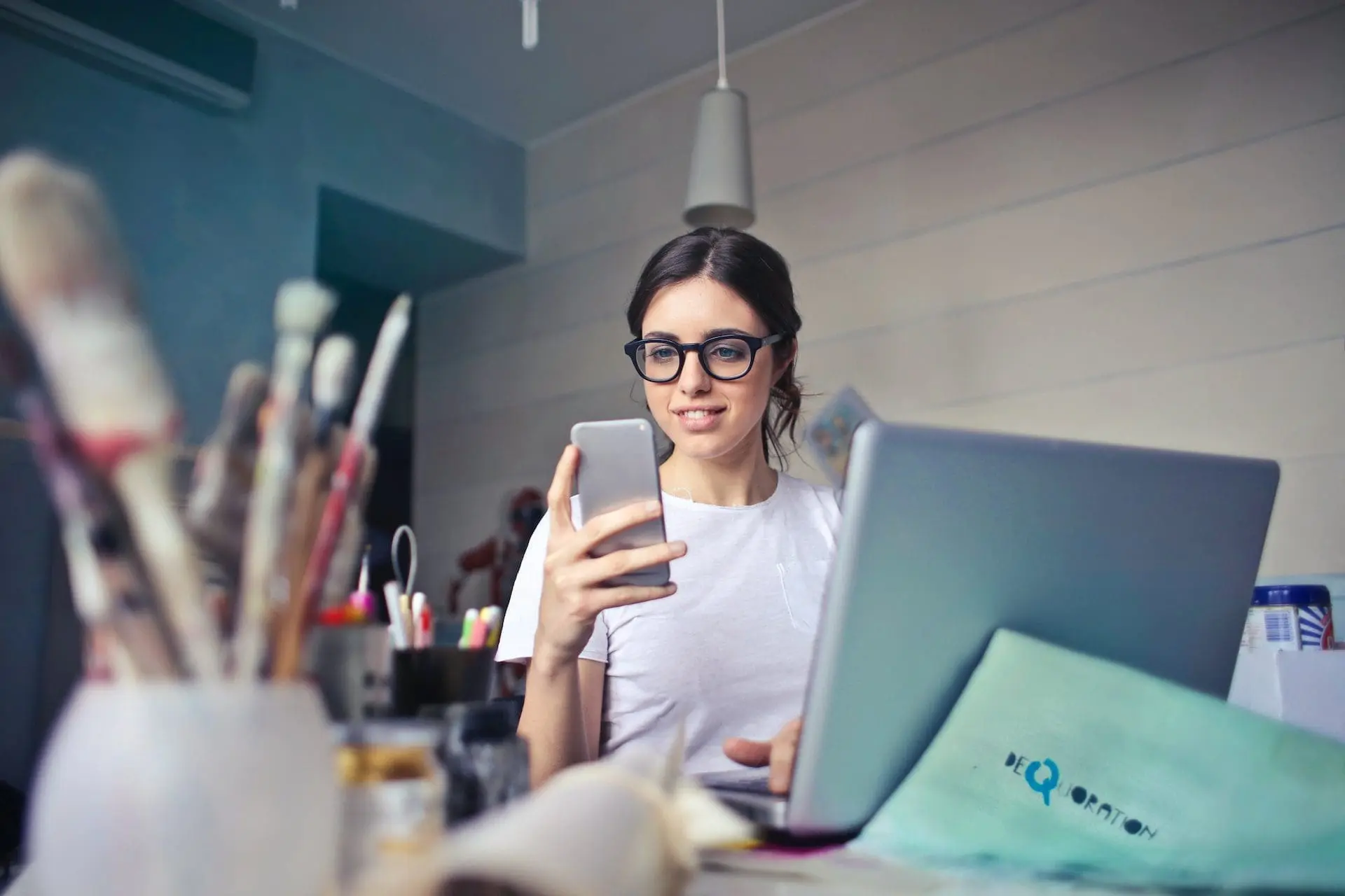 a woman using a laptop and phone