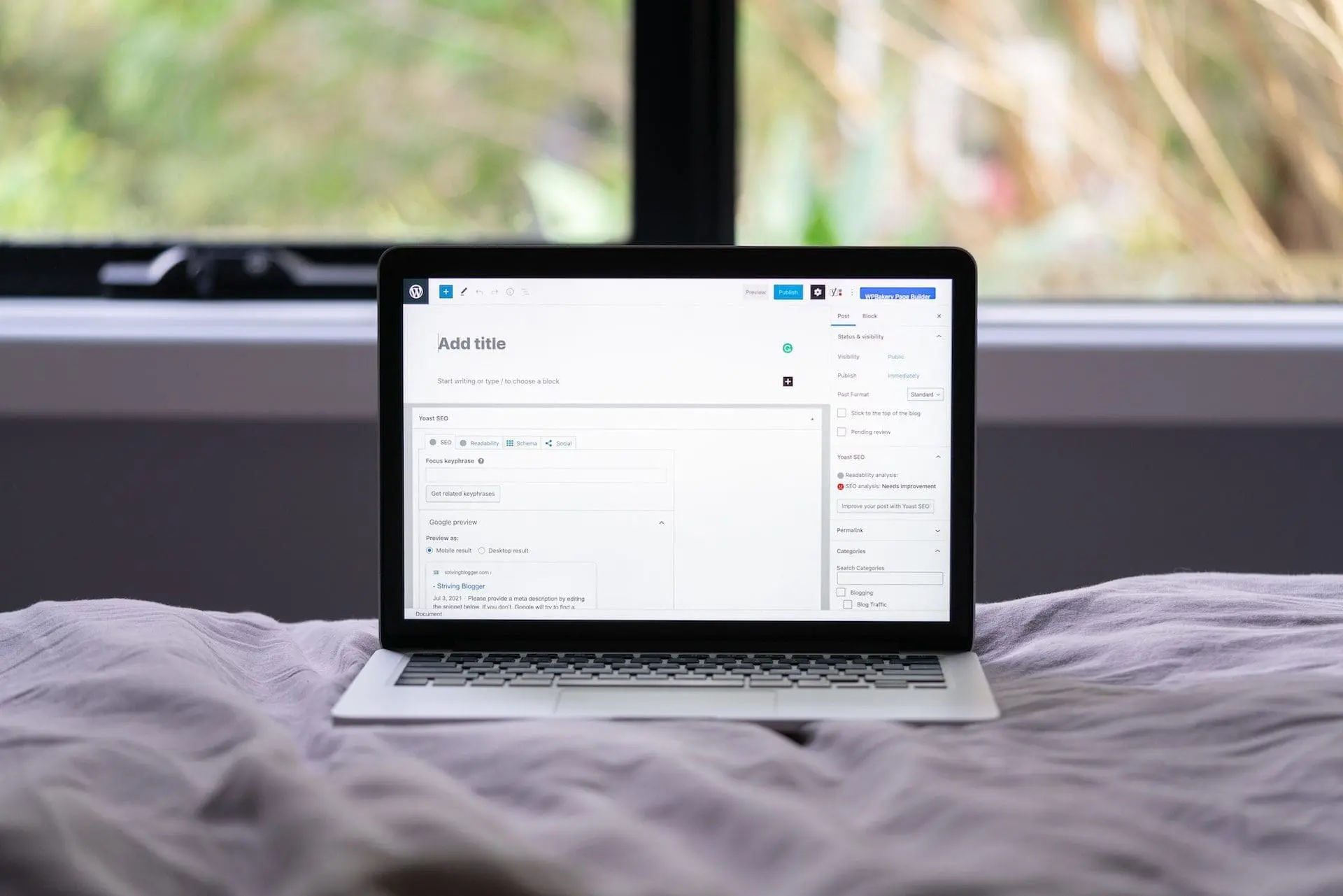 laptop on top of the bed with wordpress