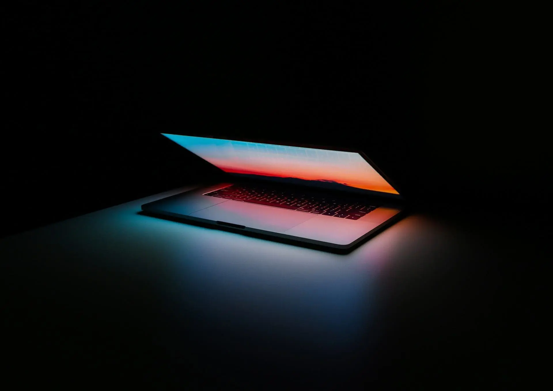 a half open macbook in black background