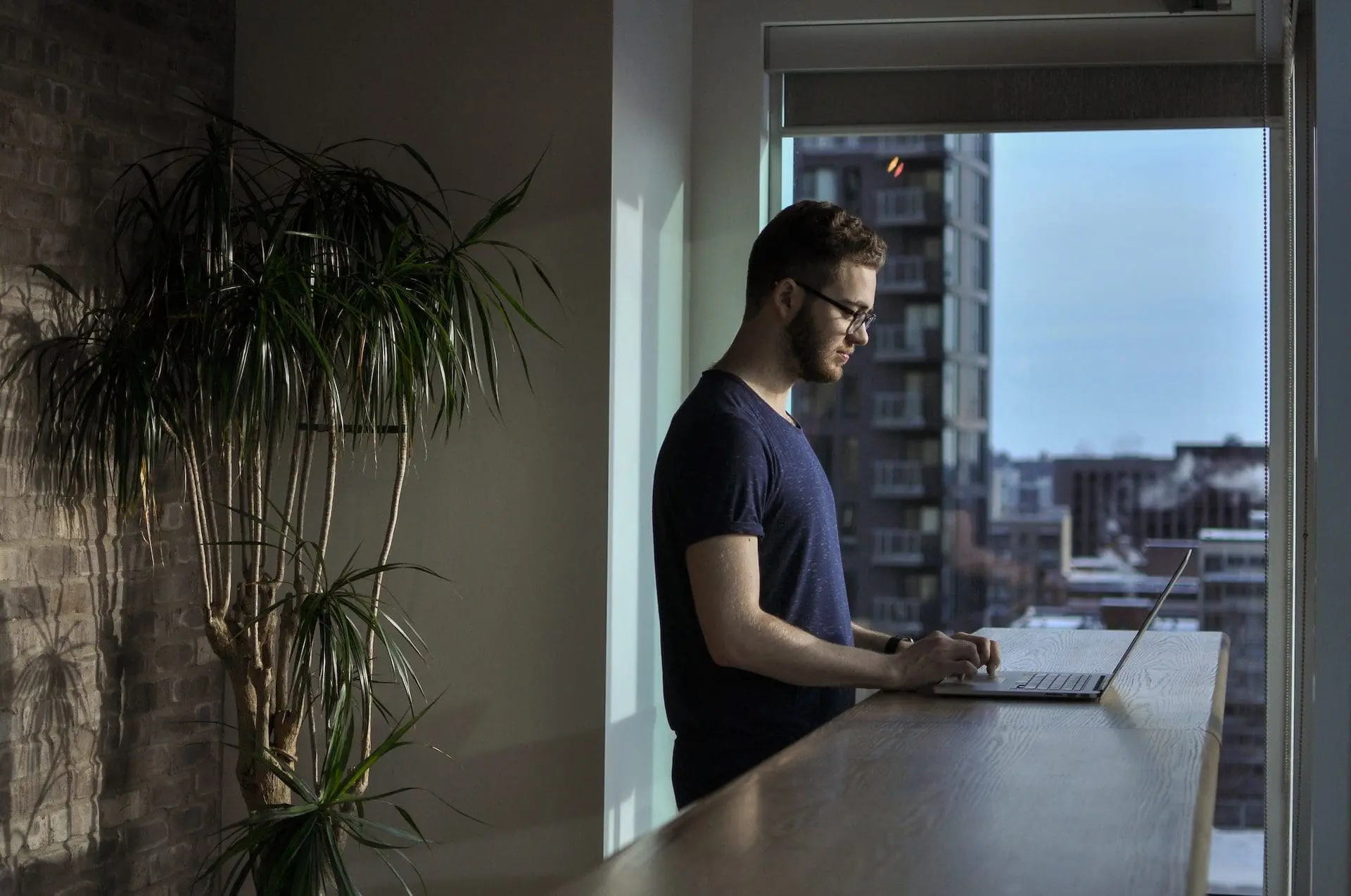a man using a laptop while standing