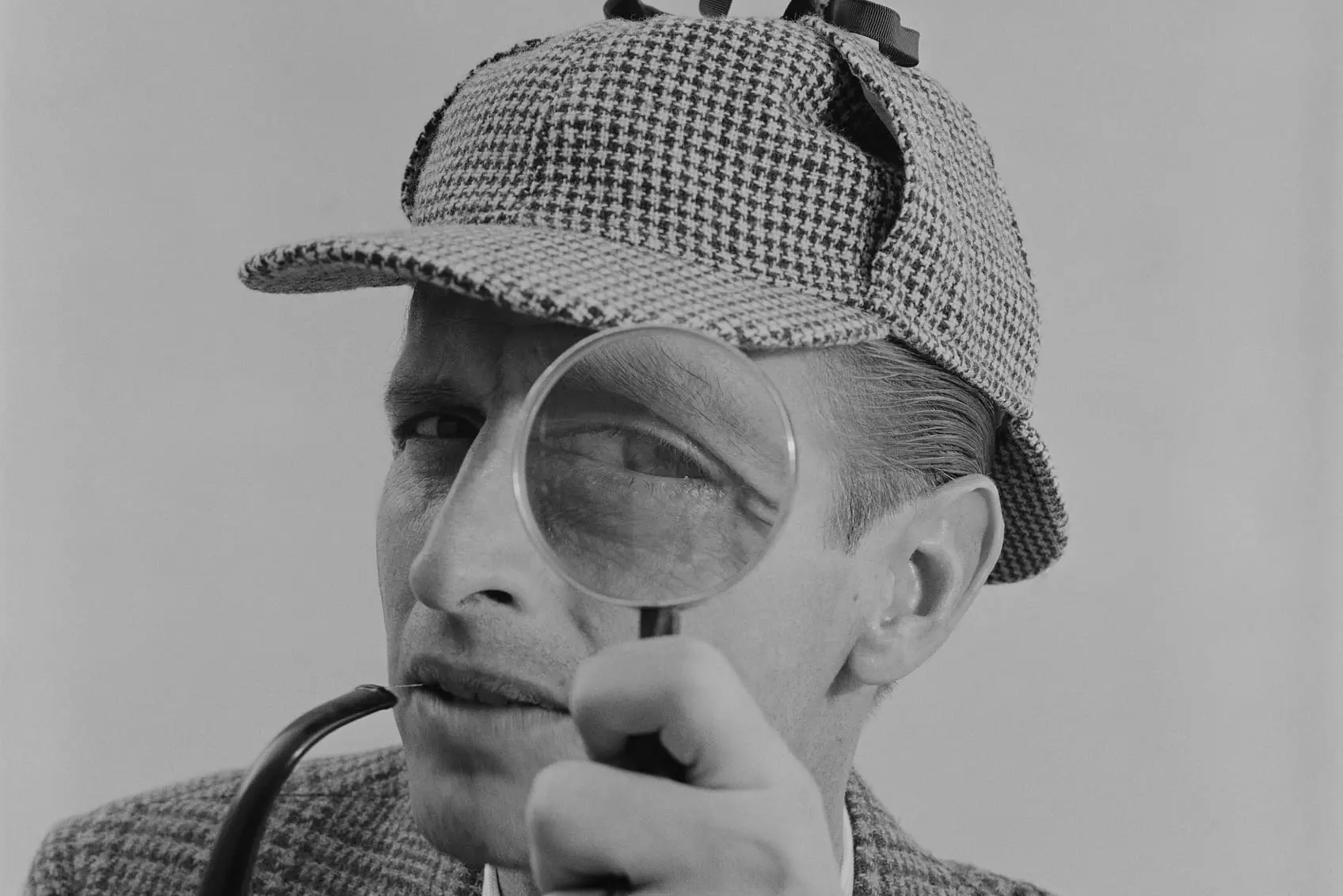 Man looking through magnifying glass - hey reliable quality assurance and testing process for web development